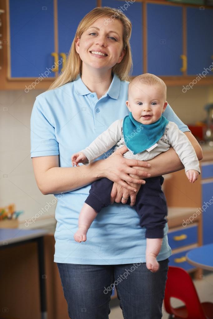 Junge Betreuerin spielt mit Kindern am Boden